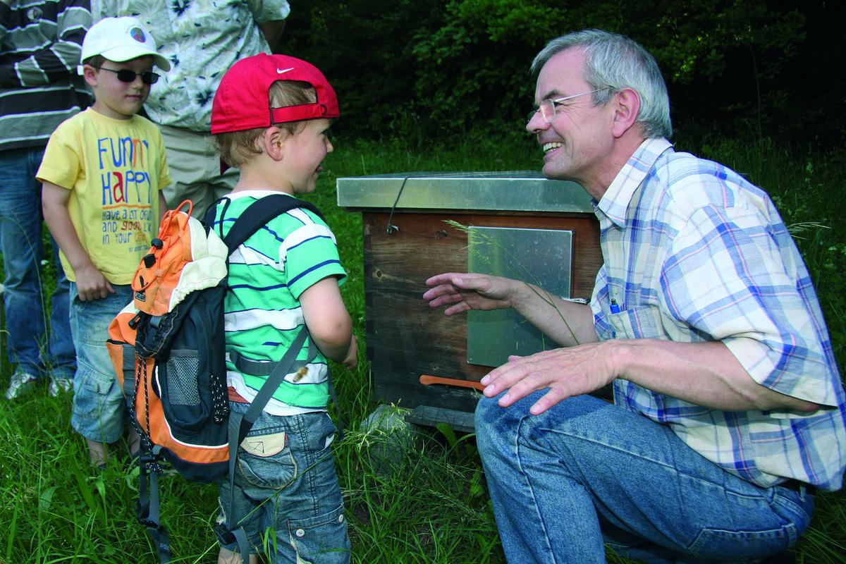 Schon jetzt besuchen Schulklassen oder Familien mit ihren Kindern an Besuchstagen die Imkerei Fischerm&uuml;hle. Hier Thomas Radetzki mit zwei kleinen Besuchern vor einem Bienenvolk. 